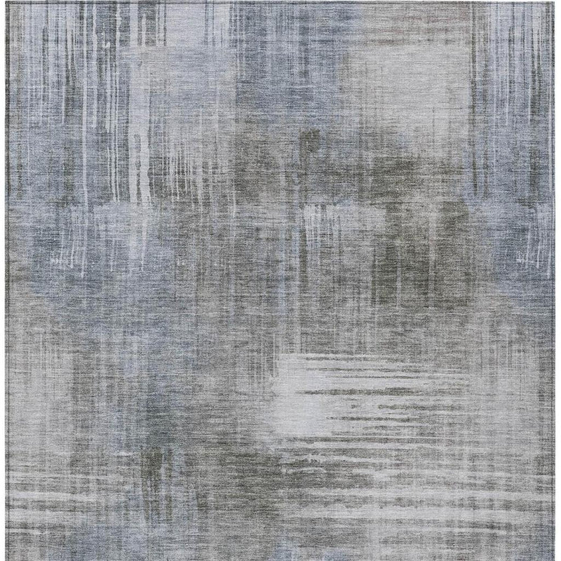 Abstract textured rug surface with subtle geometric blocks in cool gray and off-white.