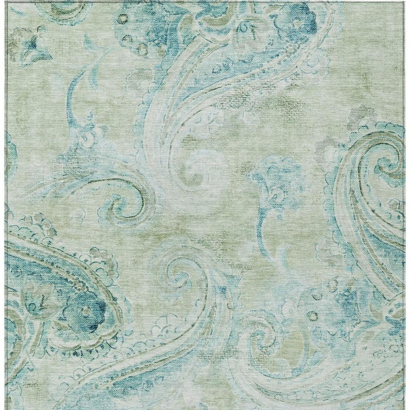 Close-up of sage-green and teal paisley area rug with distressed, textured print