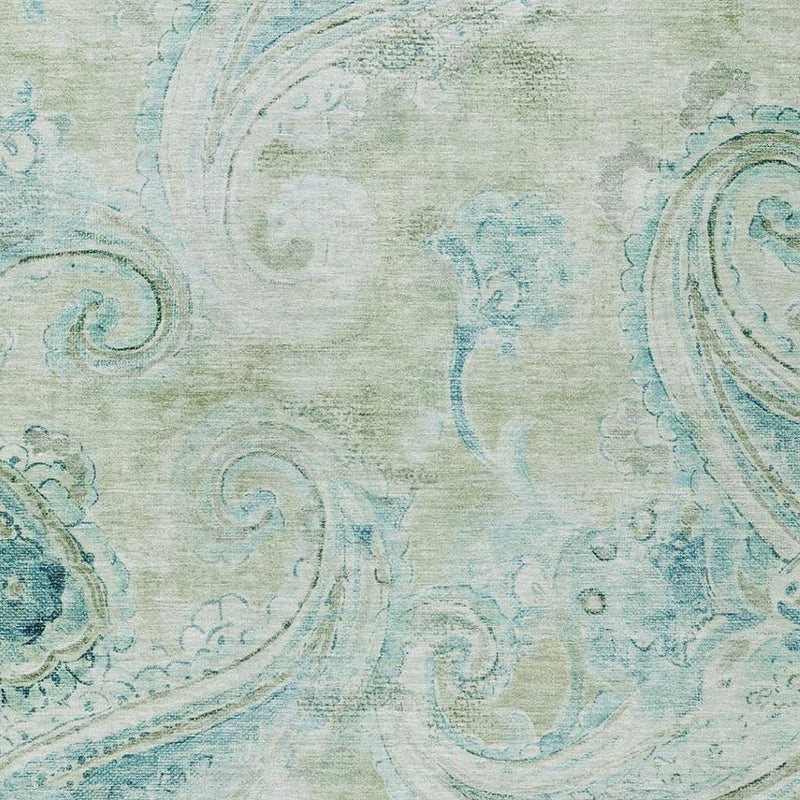 Detailed view of sage-green and teal paisley area rug texture and swirling motifs