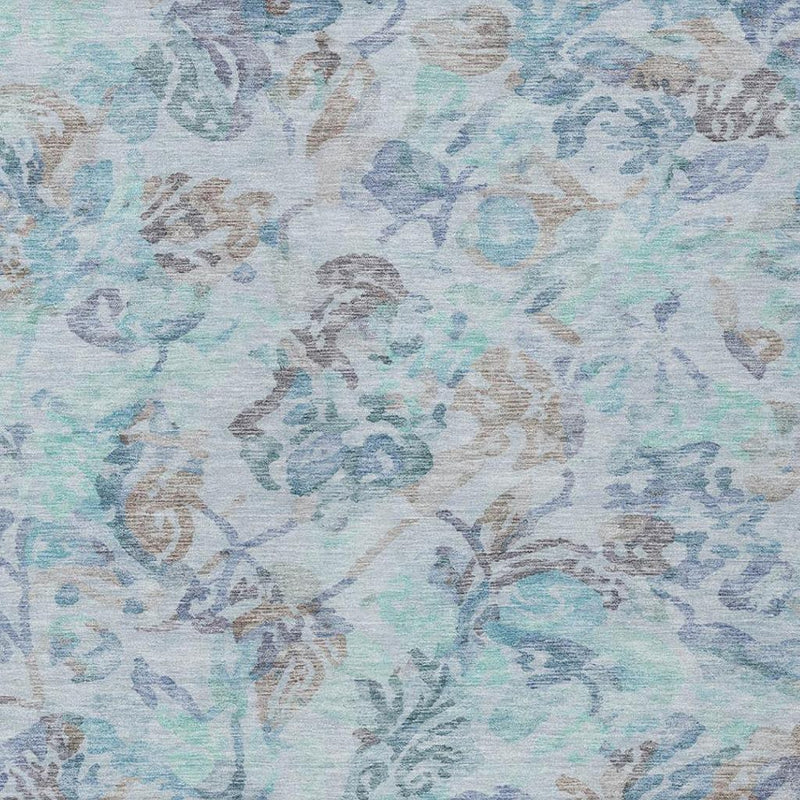 Light blue area rug with ornate floral vine motifs and distressed speckled finish