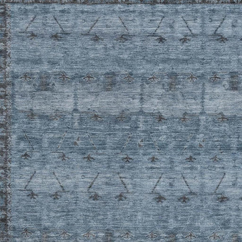 Close-up of blue and gray tribal area rug with distressed geometric pattern