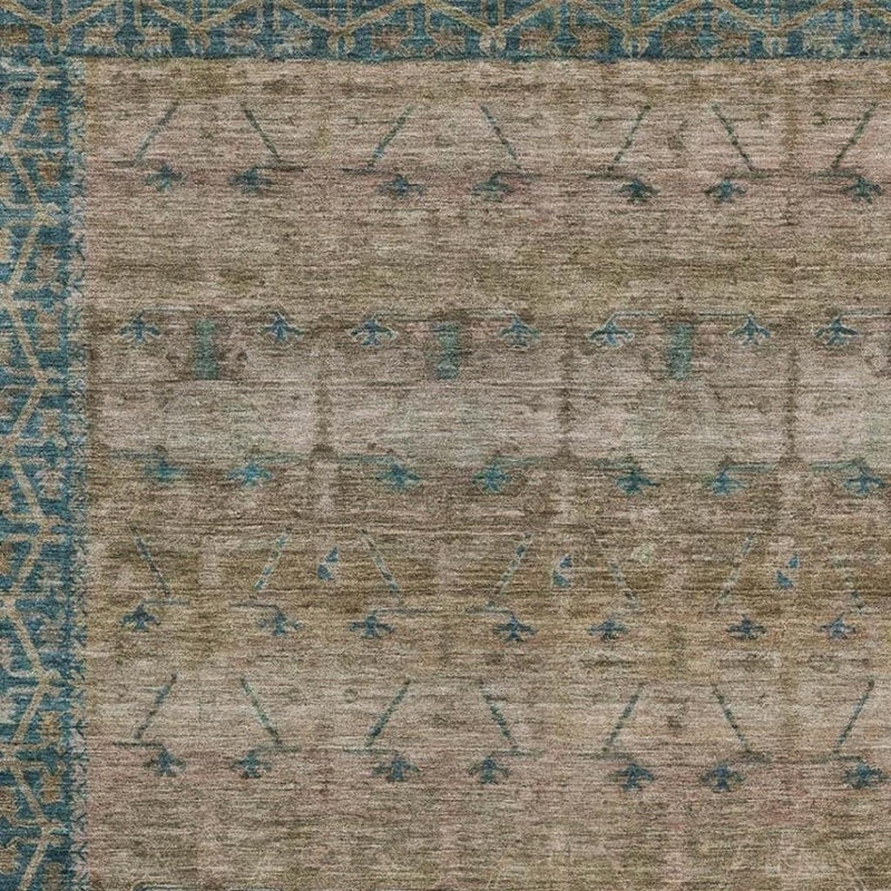Taupe area rug with teal geometric tribal motifs across the surface