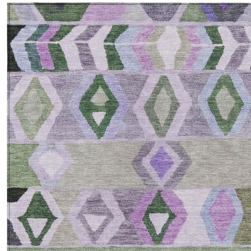 Patterned tribal area rug with lavender, green, purple, and gray interlocking shapes.