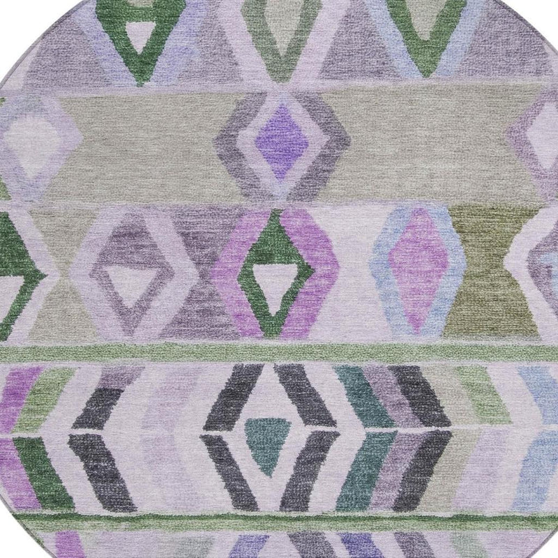 Tight crop of round rug showing geometric tribal stripes and diamonds in green and lavender hues.