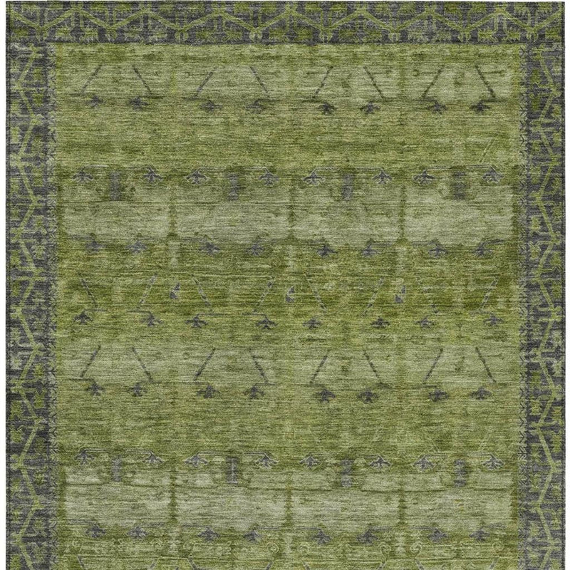 Olive green area rug with faded tribal pattern and dark green edge detailing