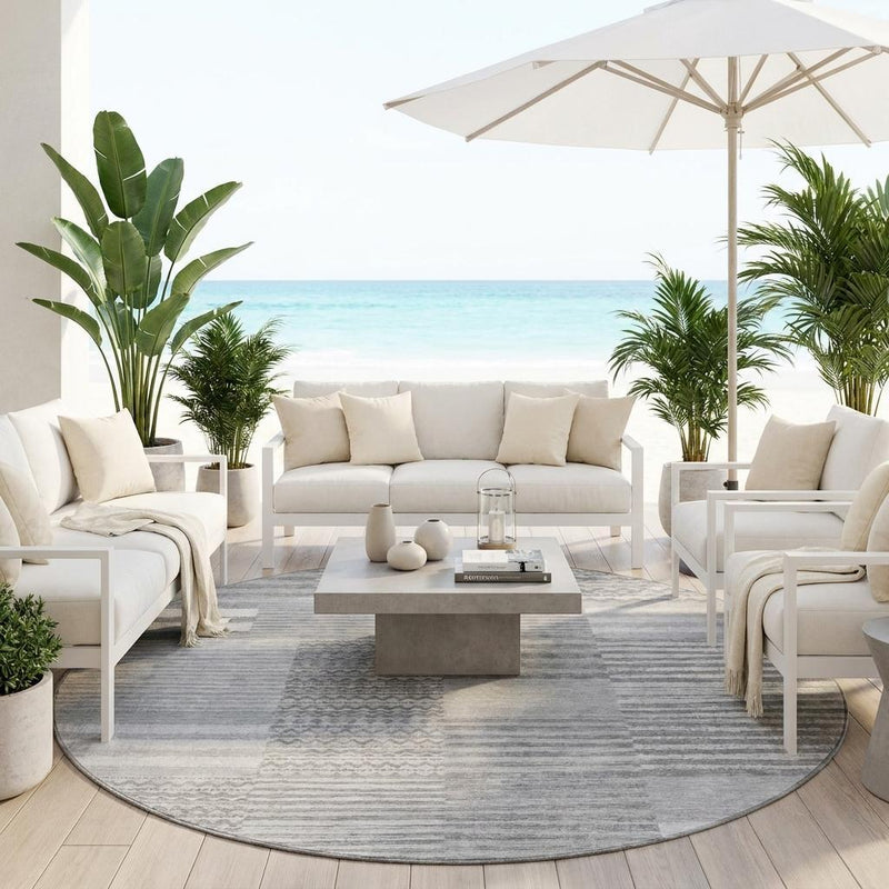 Round gray and silver striped area rug beneath outdoor seating, textured surface.