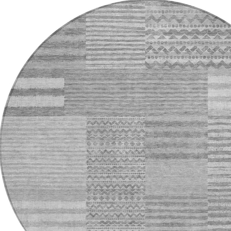 Round gray and silver striped area rug with central geometric band detail.