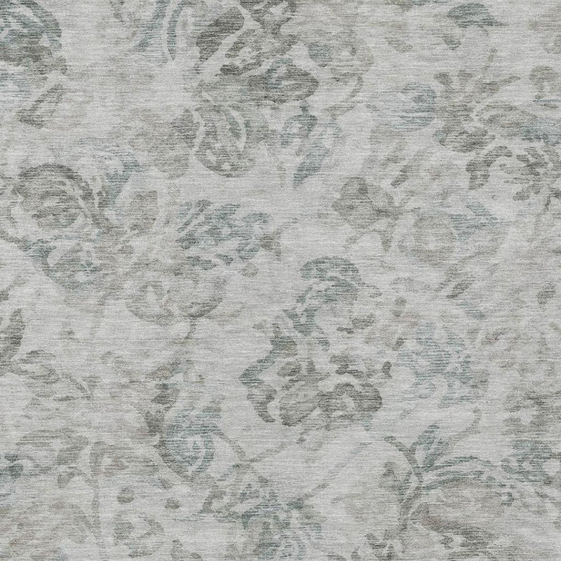 Light taupe area rug with distressed teal floral pattern texture close-up