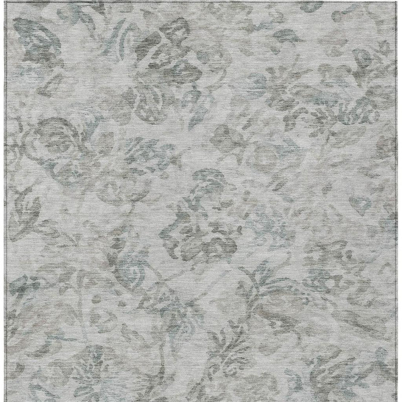 Rectangular light taupe area rug with muted teal floral design and subtle speckle