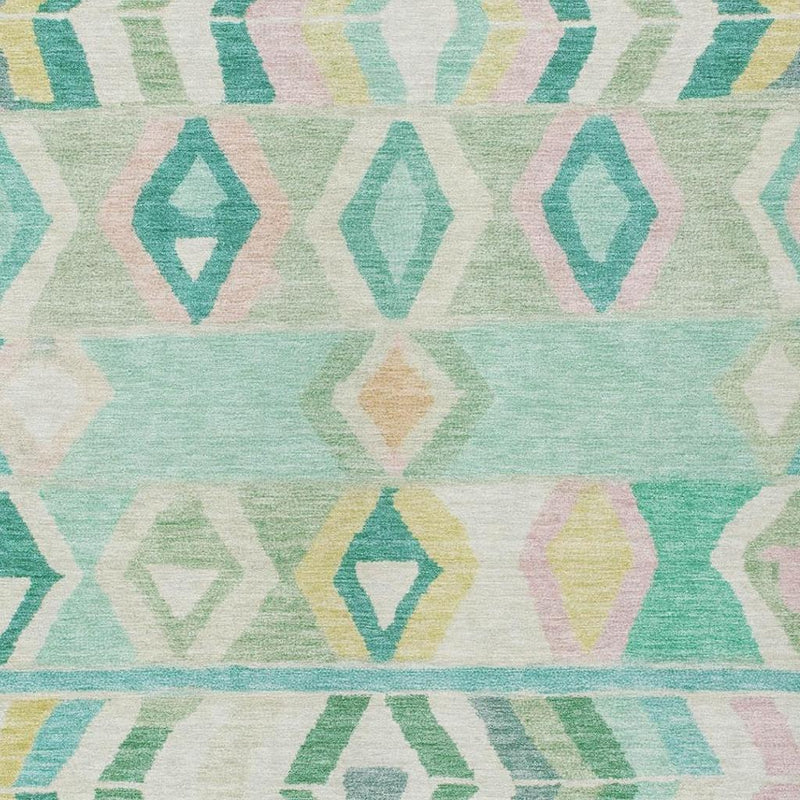 Close-up turquoise, teal, and green diamond and arrow pattern on a cream rug