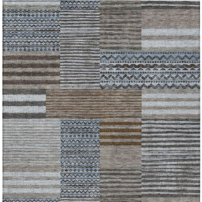 Textured patchwork rug with striped sections and blue geometric borders