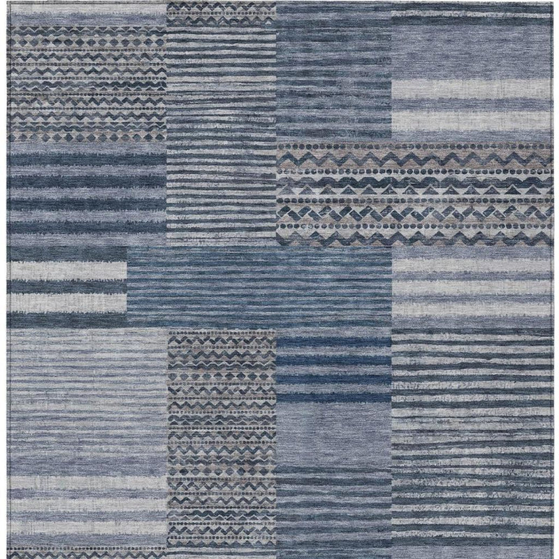 Blue and gray patchwork area rug with stripe, grid, and woven motif sections