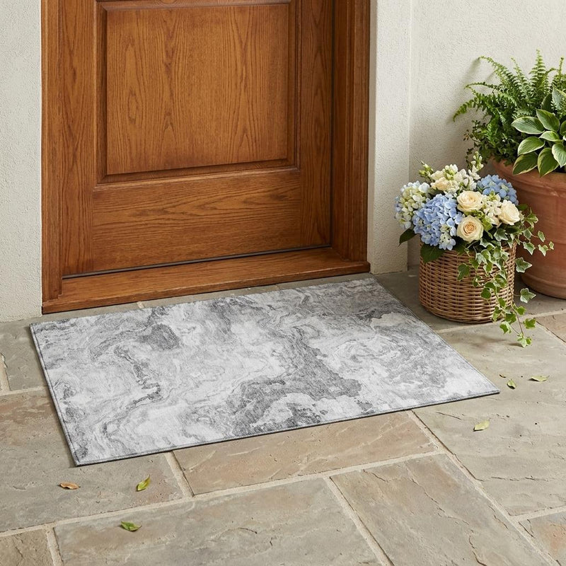 Gray and silver abstract area rug on stone floor, rectangular washable design