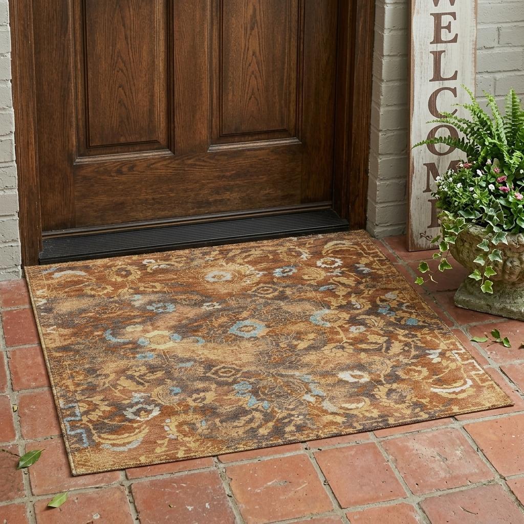 Floral area rug with rust, tan, gray, and blue distressed pattern, wide angle