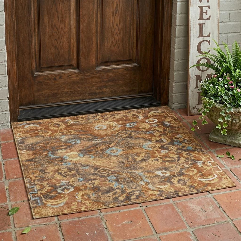Floral area rug with rust, tan, gray, and blue distressed pattern, wide angle