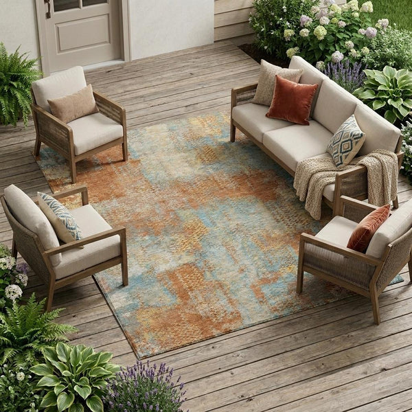 Indoor outdoor area rug with rust-orange, blue and beige abstract pattern on floor.