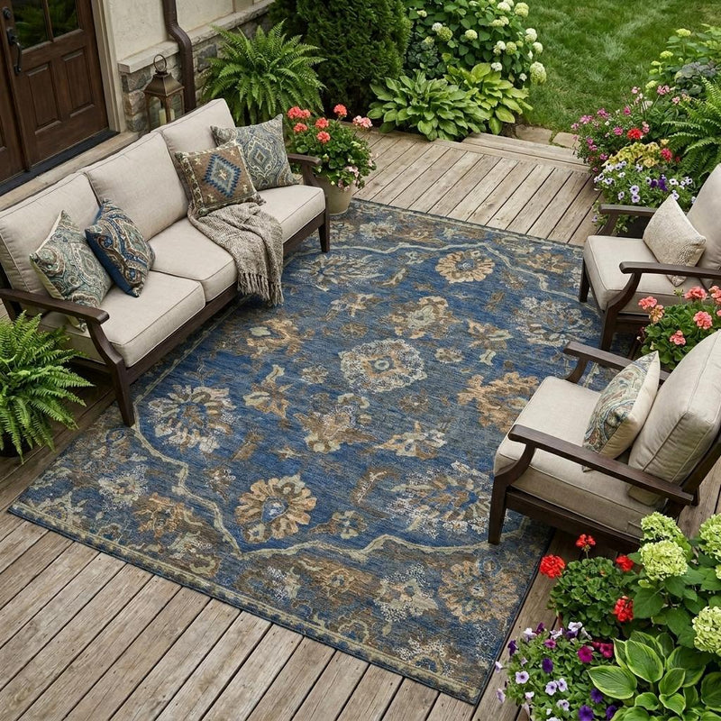 Outdoor area rug with navy blue medallion floral design laid on wooden deck