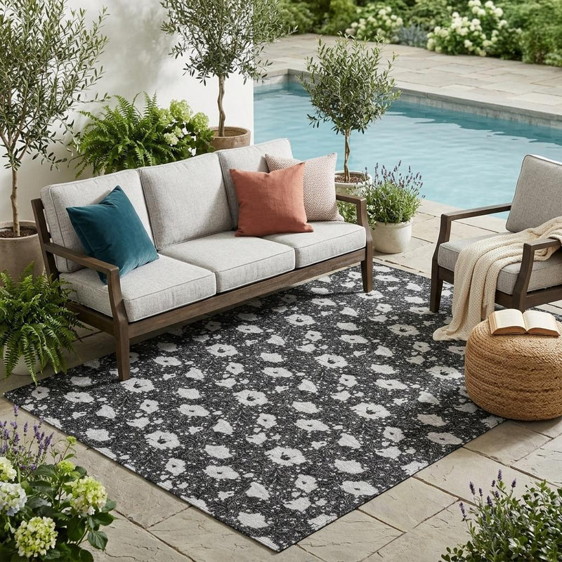 Rectangular washable indoor/outdoor floral area rug, black and light gray distressed pattern