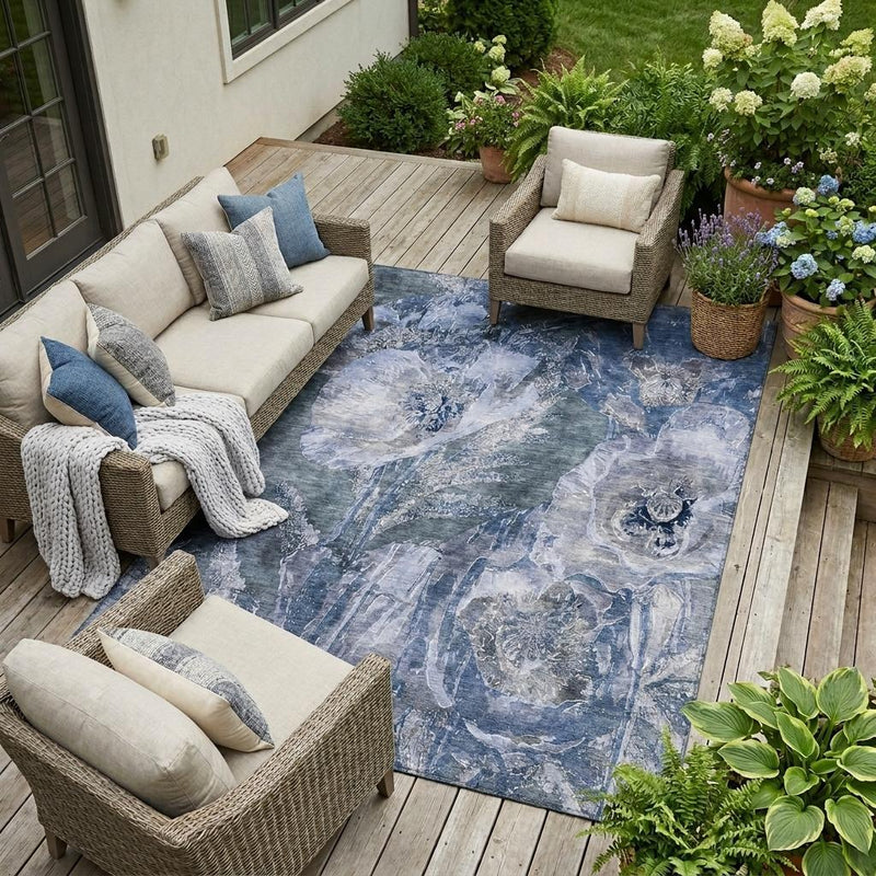 Indoor/outdoor area rug with blue and lavender floral abstract pattern, laid on deck