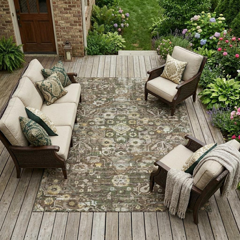 Outdoor patio area rug with distressed floral medallion pattern under chairs