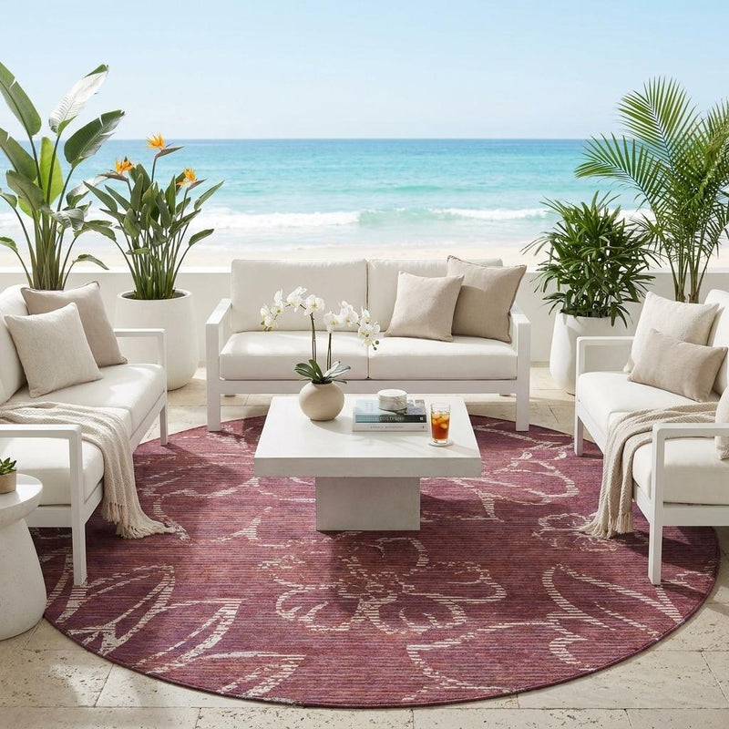 Round maroon outdoor rug with distressed white floral pattern on floor
