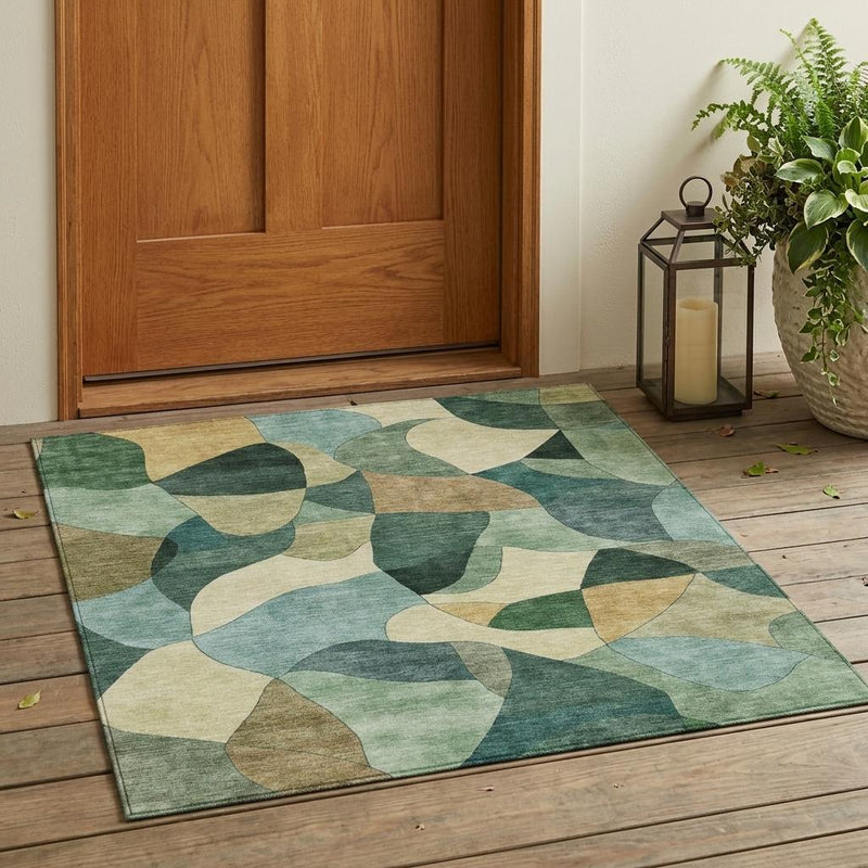 Abstract indoor outdoor area rug with green and beige organic pattern on a flat surface