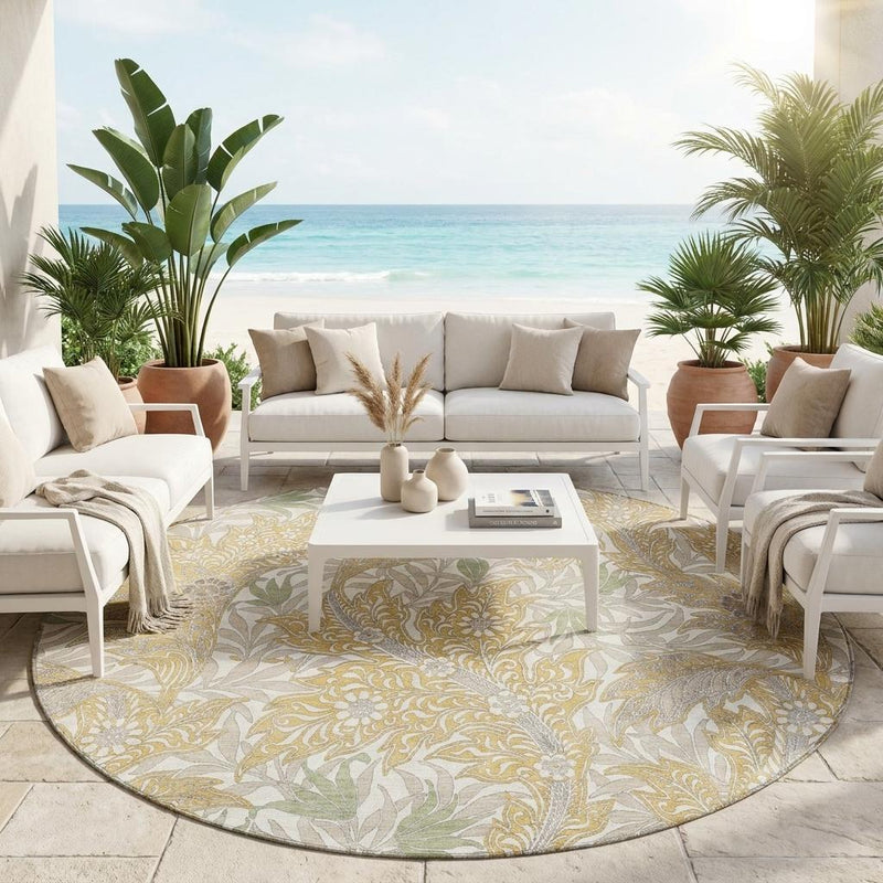 Round outdoor area rug with botanical leaf design in gold and silver on light gray