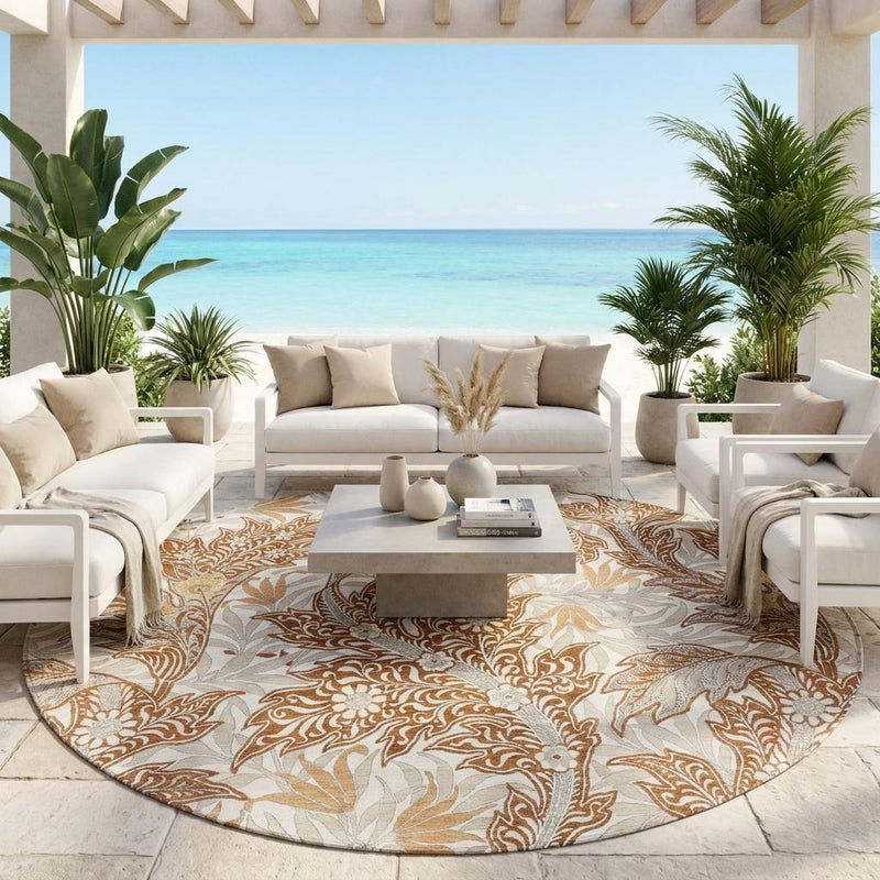 Round outdoor area rug with orange and khaki botanical pattern beneath patio seating