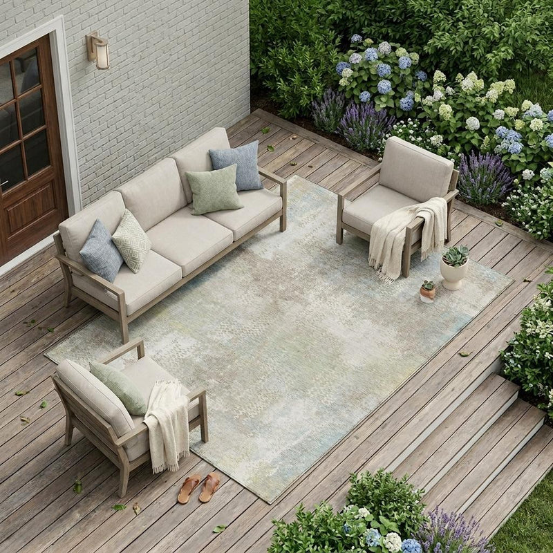 Indoor outdoor area rug in ivory and silver with an abstract distressed design