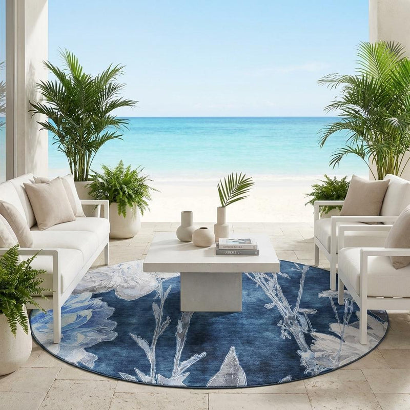 Round indoor/outdoor area rug with dark navy and light-blue floral botanical pattern