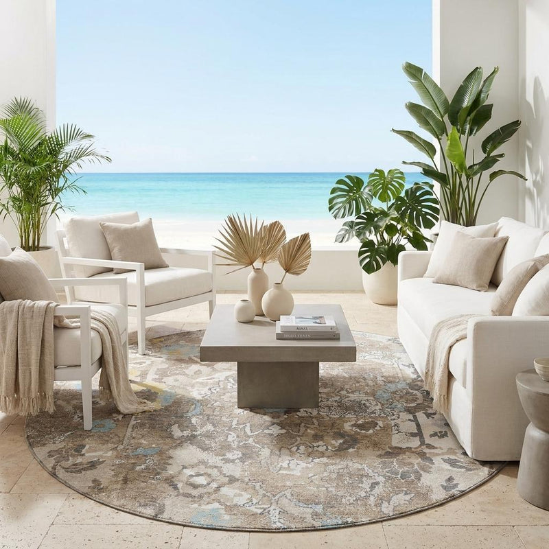 Round floral area rug on floor, ivory and pewter with light blue accents