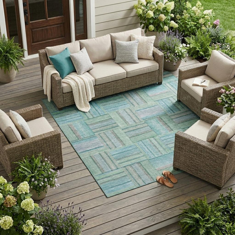 Teal and aqua geometric area rug laid on an outdoor patio floor