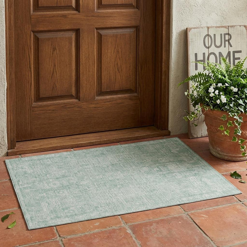 Mint-aqua area rug with distressed oriental pattern and low-profile weave.