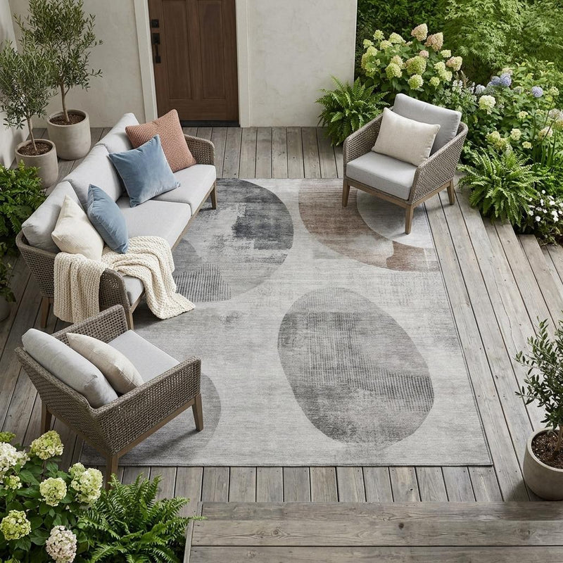 Large taupe-and-brown geometric indoor outdoor rug with abstract oval pattern on gray