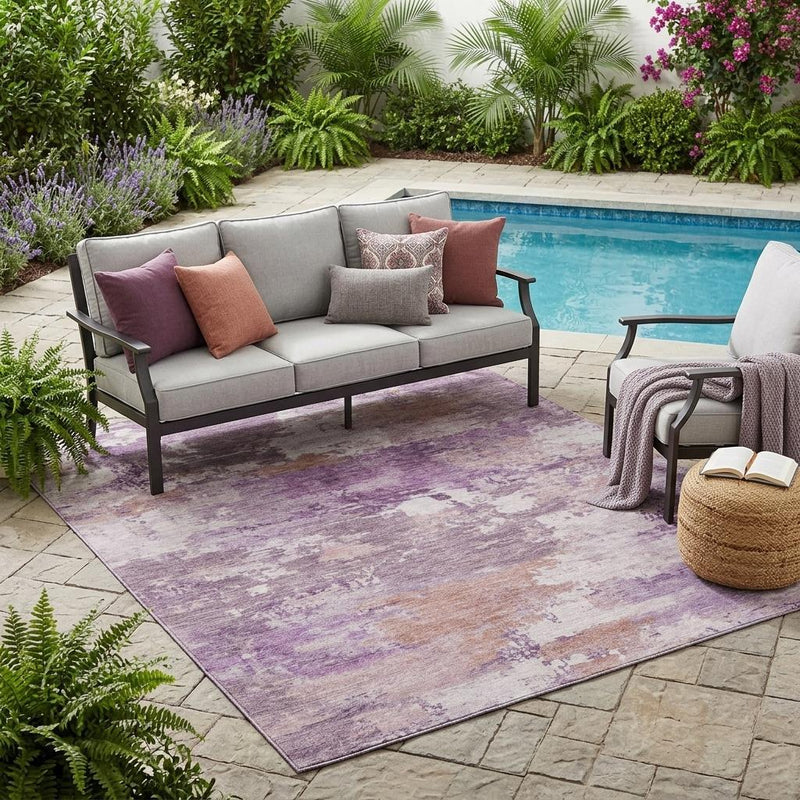 Abstract indoor/outdoor area rug with plum and purple distressed wash pattern