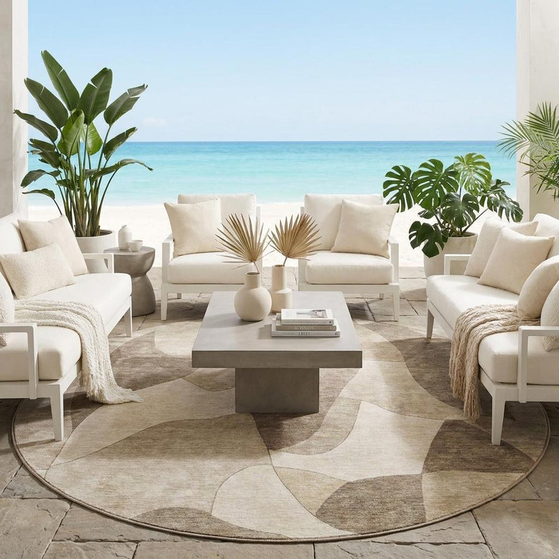 Round abstract area rug in beige and brown, placed in an indoor patio setting