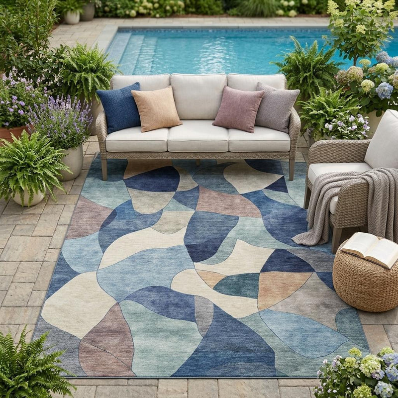 Abstract indoor/outdoor area rug with blue and navy rounded geometric pattern on cream