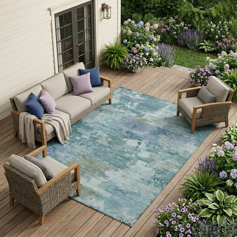 Teal blue abstract area rug with distressed silver pattern in outdoor setting