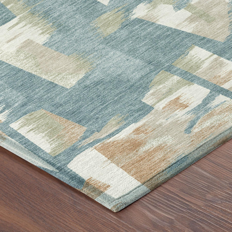 Corner detail of teal blue abstract area rug with beige and cream block pattern
