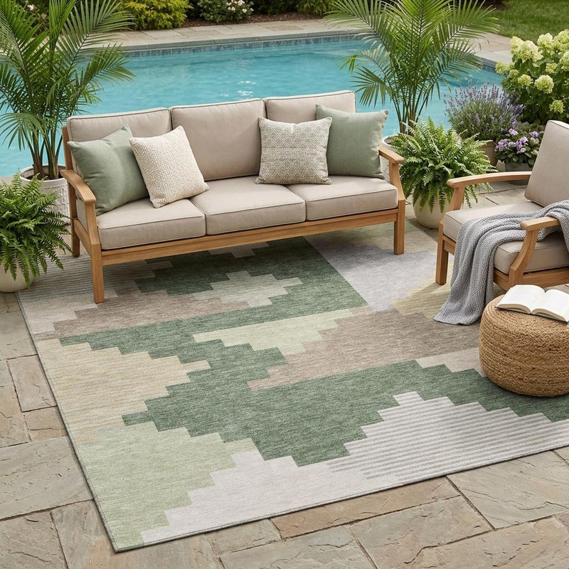 Outdoor geometric area rug with green and gray patchwork blocks on light beige.