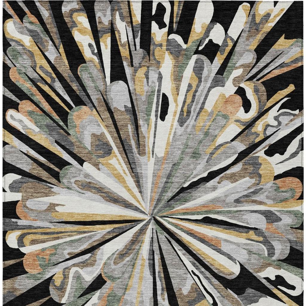 Abstract area rug with radial starburst pattern in black, gray, tan, and gold tones.