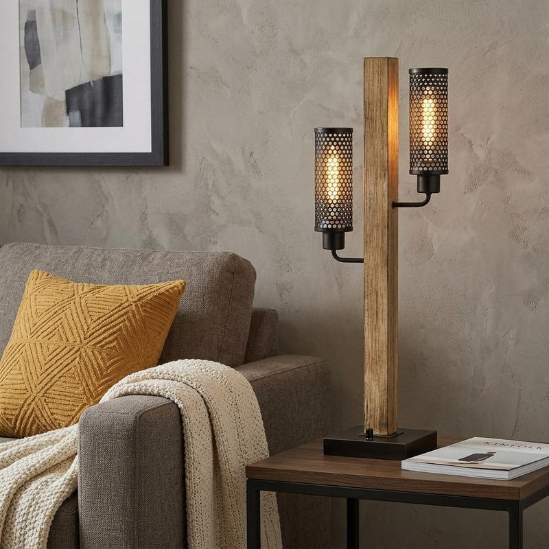 Two-light table lamp with wood post and black mesh shades on dark tabletop