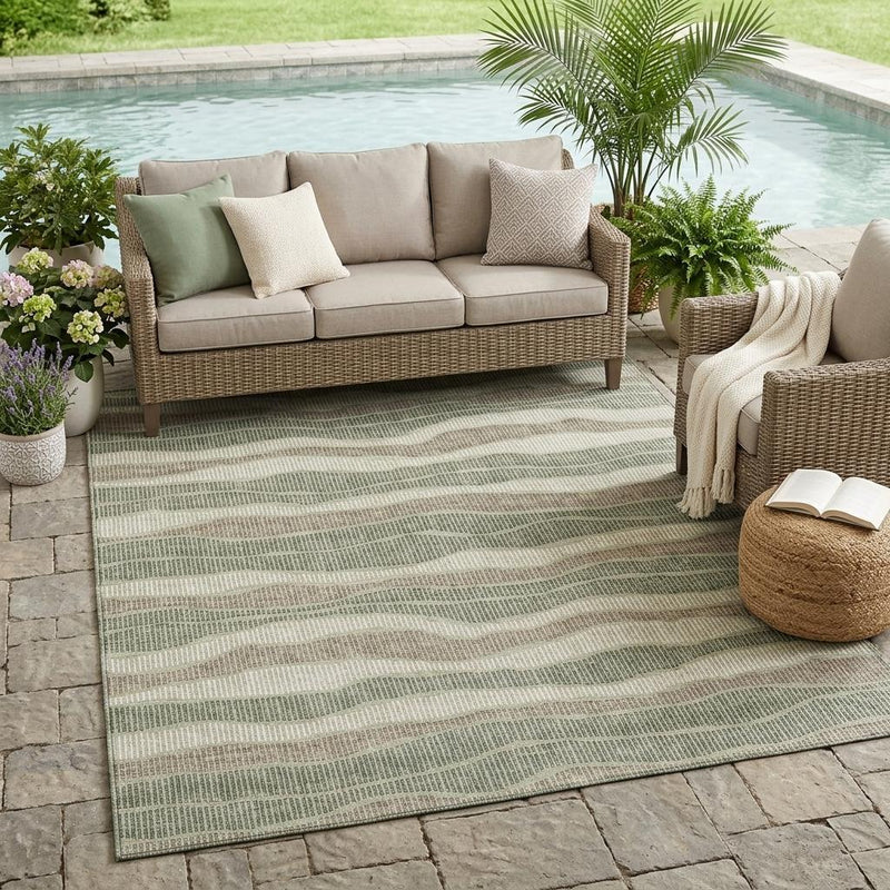 Striped area rug with wavy bands in sage green and beige for indoor outdoor use