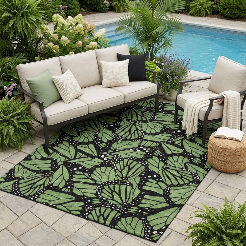 Green and black butterfly-pattern indoor outdoor area rug with large leaf silhouettes