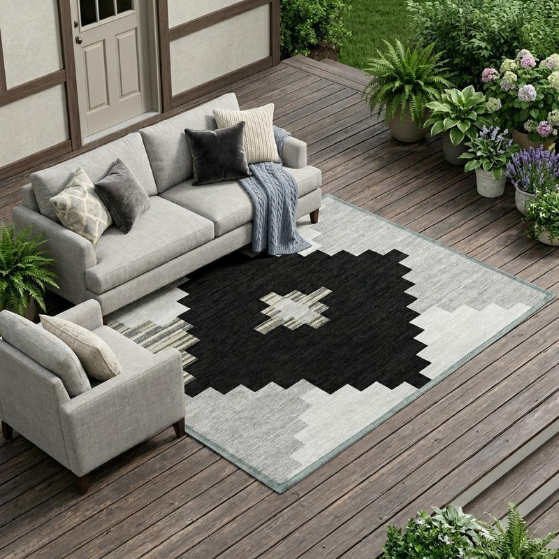 Indoor outdoor area rug with black and light gray geometric star and zigzag blocks