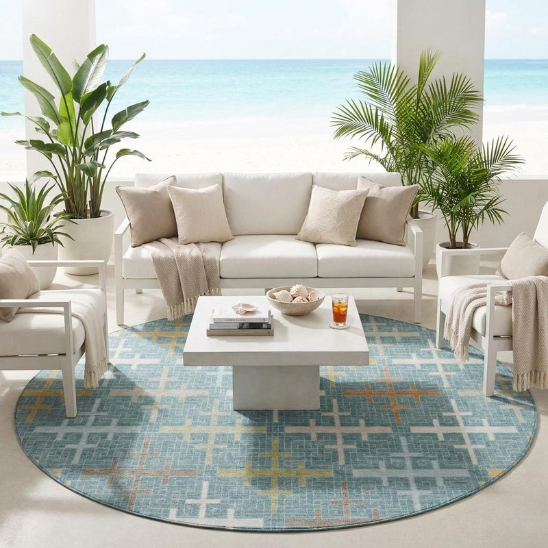 Round teal blue geometric rug with white and gold cross motifs