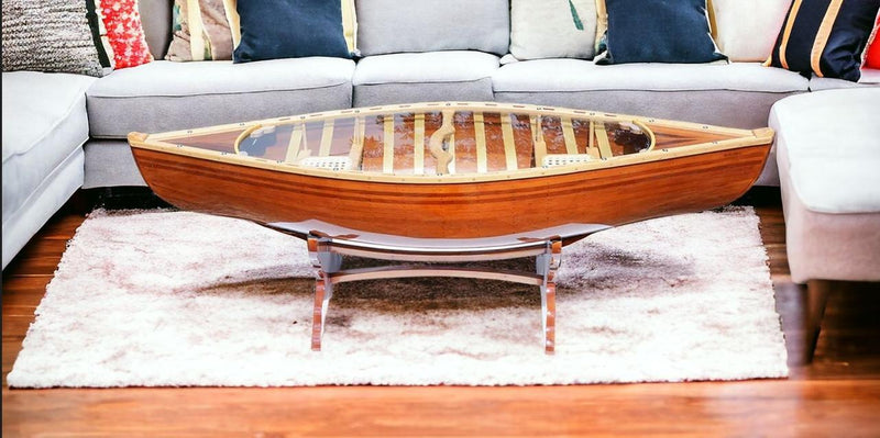 Wooden canoe-shaped coffee table with glass insert and raised edges