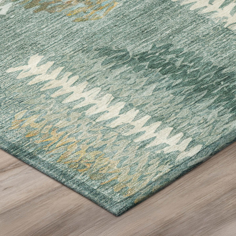 Corner view of teal abstract area rug with cream and tan chevron pattern