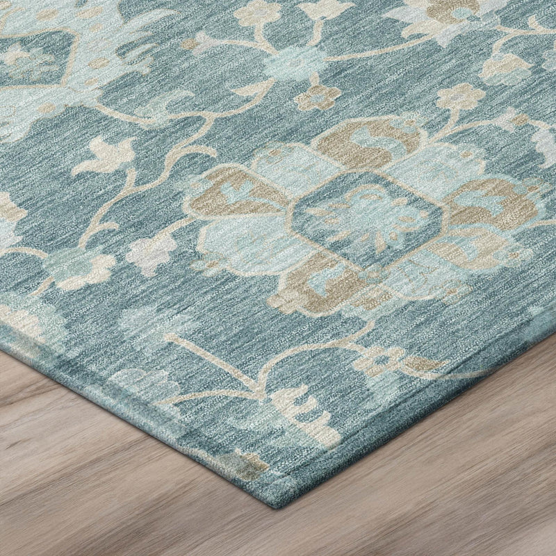 Teal blue rug corner with distressed floral vines in silver and cream