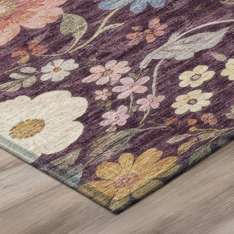 Corner detail of plum floral area rug with textured weave and multicolor blossoms